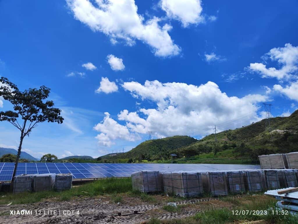 paneles solares almacenados en sus cajas delante de paneles solares instalados