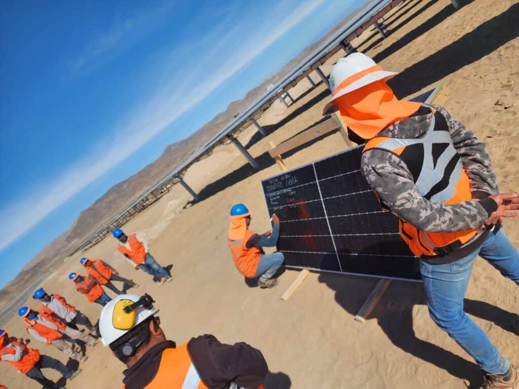 equipo de trabajaores en obra en desierto firmando un panel solar